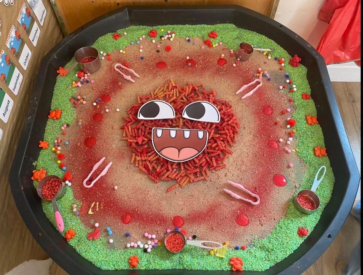 A colourful sensory tray with rice, pasta and tweezers