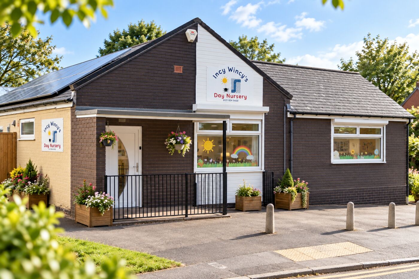 The front of Incy Wincys Day Nursery, with flower planters and the nursery sign above the door