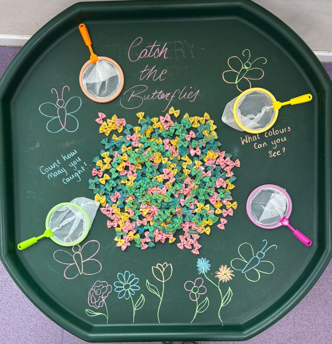 A ‘Catch the Butterflies’ sensory tray with pasta butterflies and nets