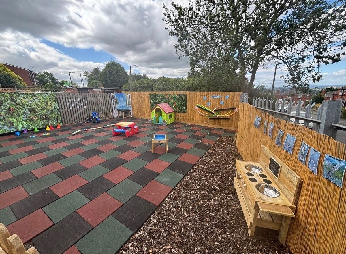 The outdoor play area with a mud kitchen and play house