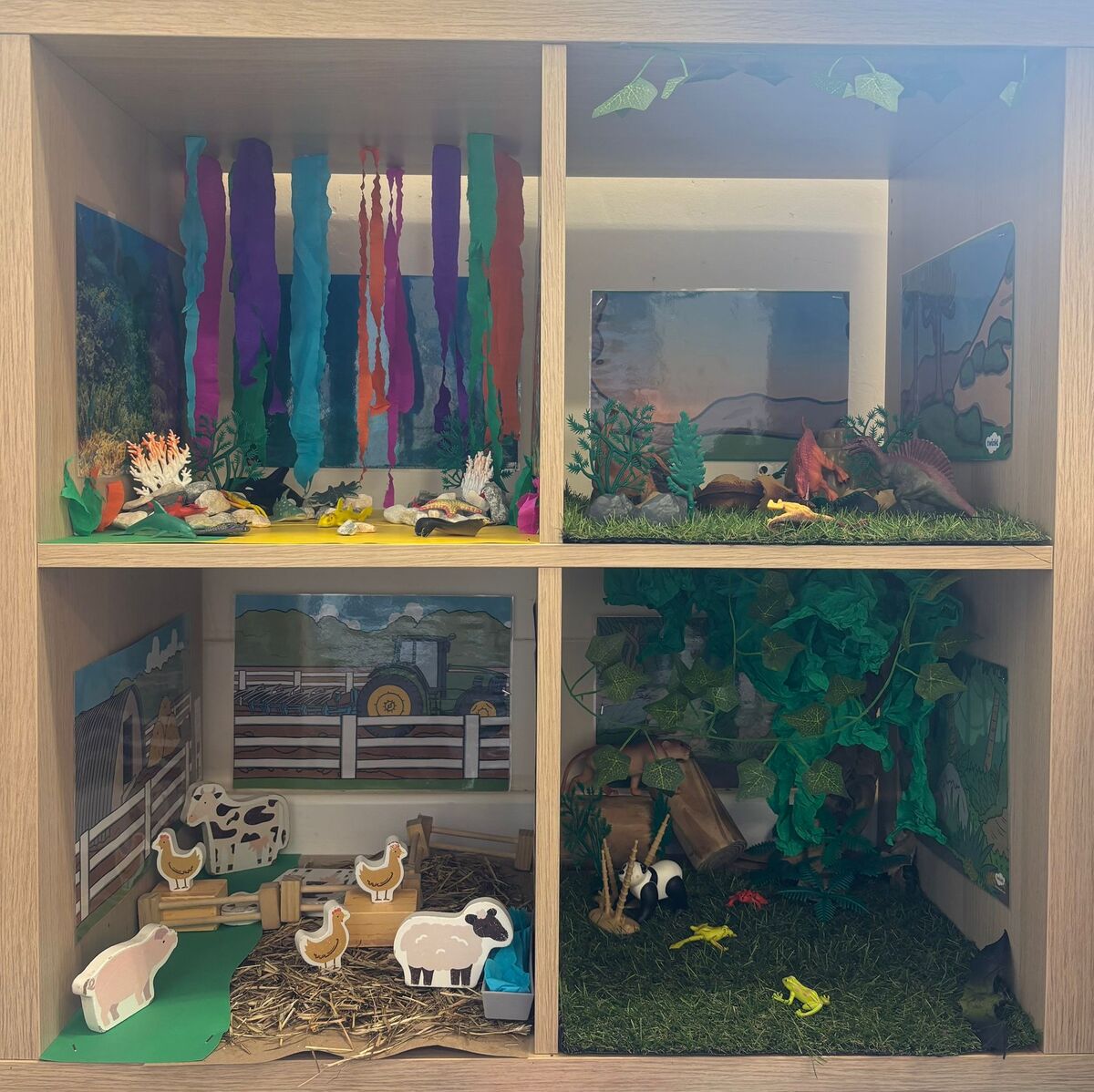 A small world display with farm, jungle and sea scenes