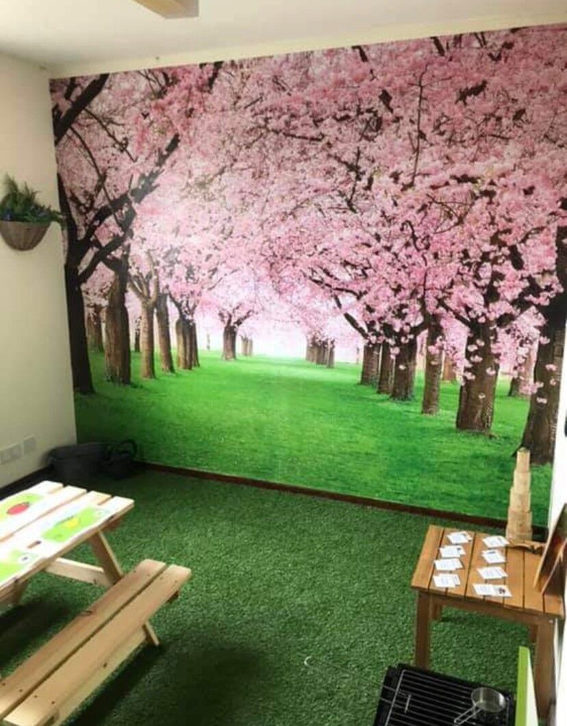 A cherry blossom wall mural with a picnic bench and play area