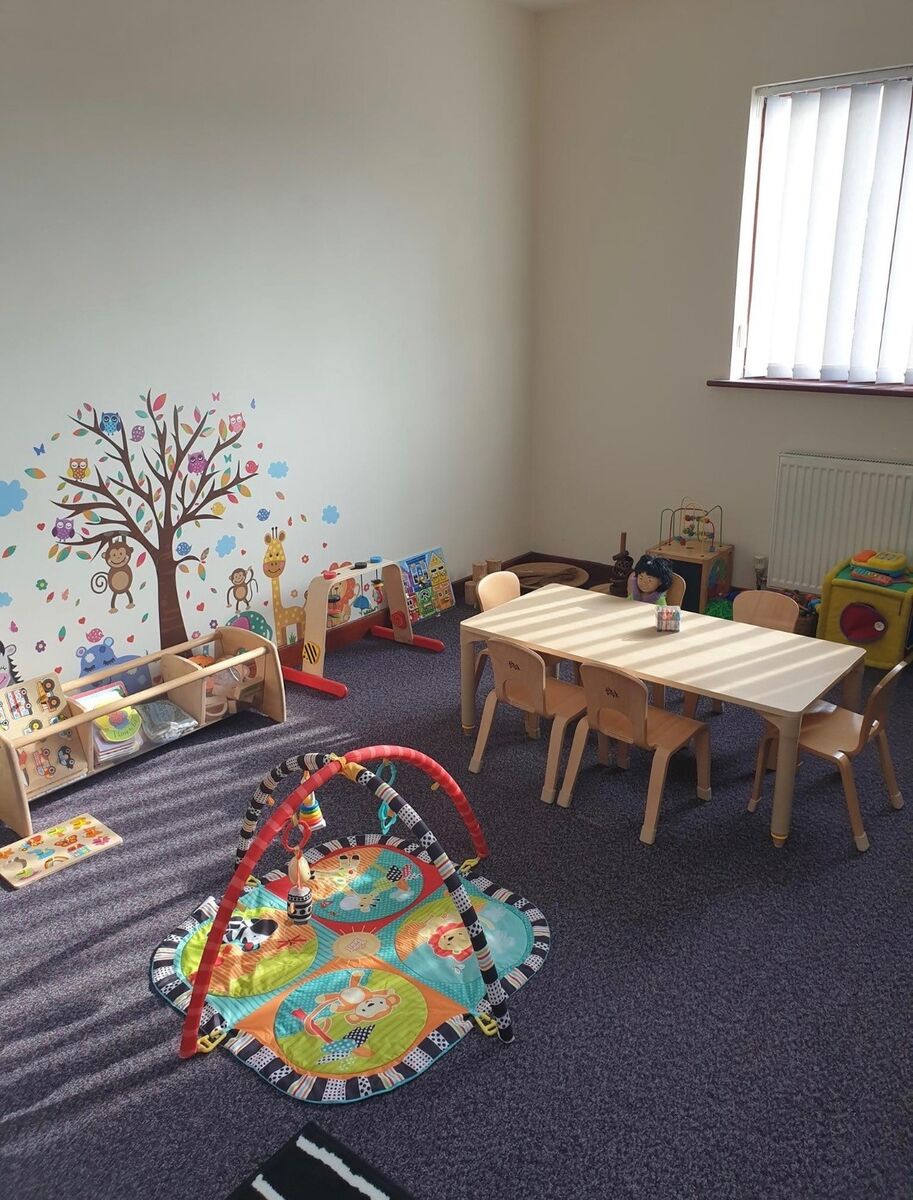 The baby room, with a play mat, low tables and a soft play tree wall